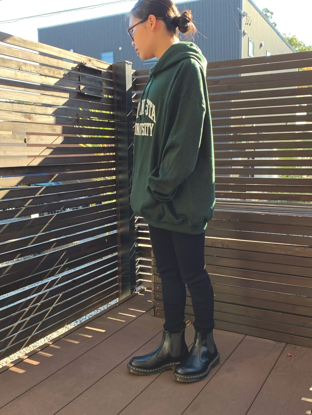 グリーン系のパーカー、ブラック系のブーツ、ブラック系のレギンス/スパッツを着用したキッズの冬コーディネートの4枚目の写真