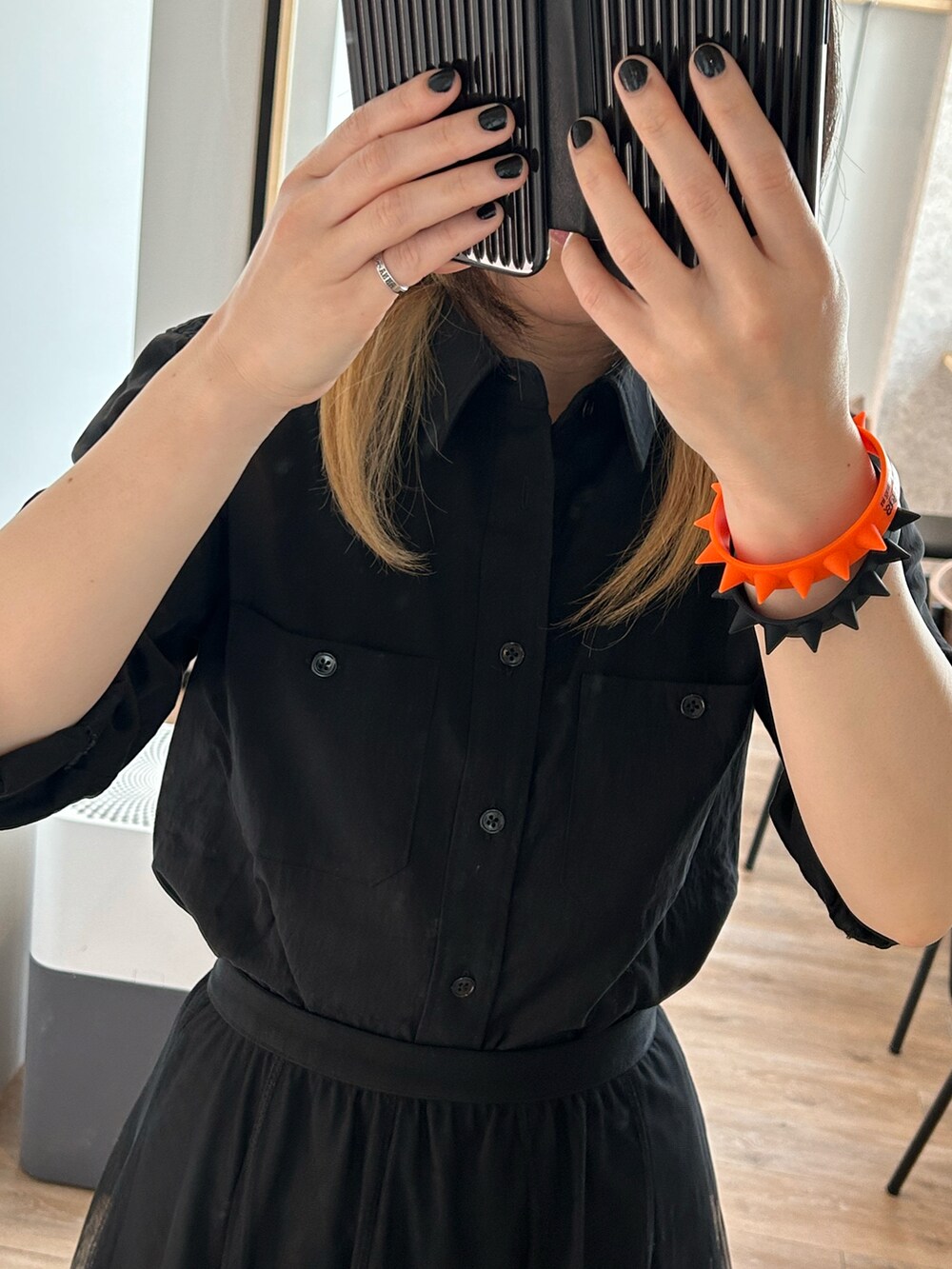 ブラック系のスカート、ブラック系のバッグ、ホワイト系のシューズを着用したレディースの春コーディネートの2枚目の写真