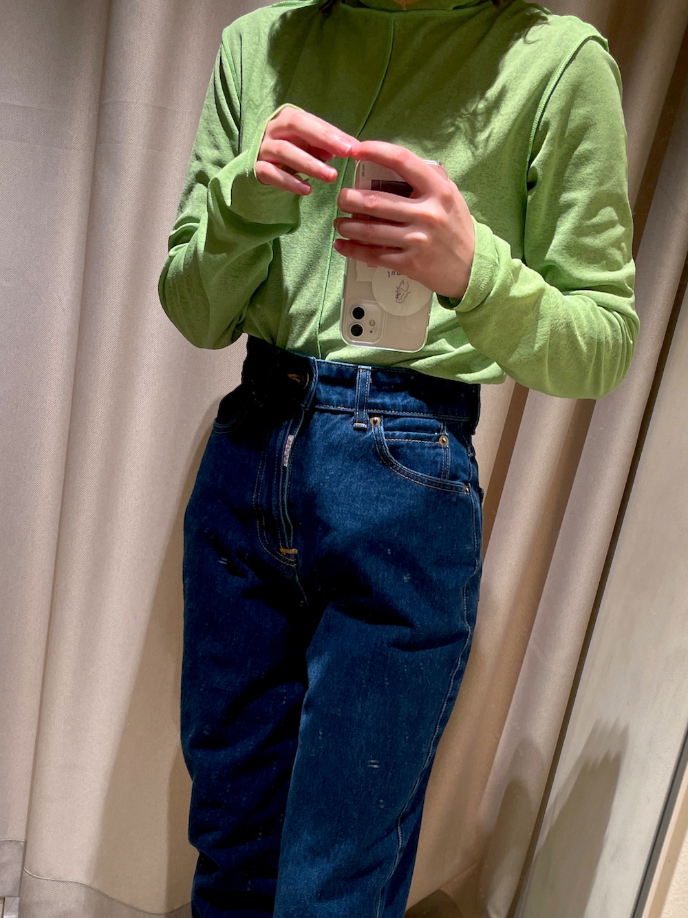 ブルー系のデニムパンツ、ブラック系のニット/セーター、グリーン系のシャツ/ブラウスを着用したレディースの冬コーディネートの2枚目の写真