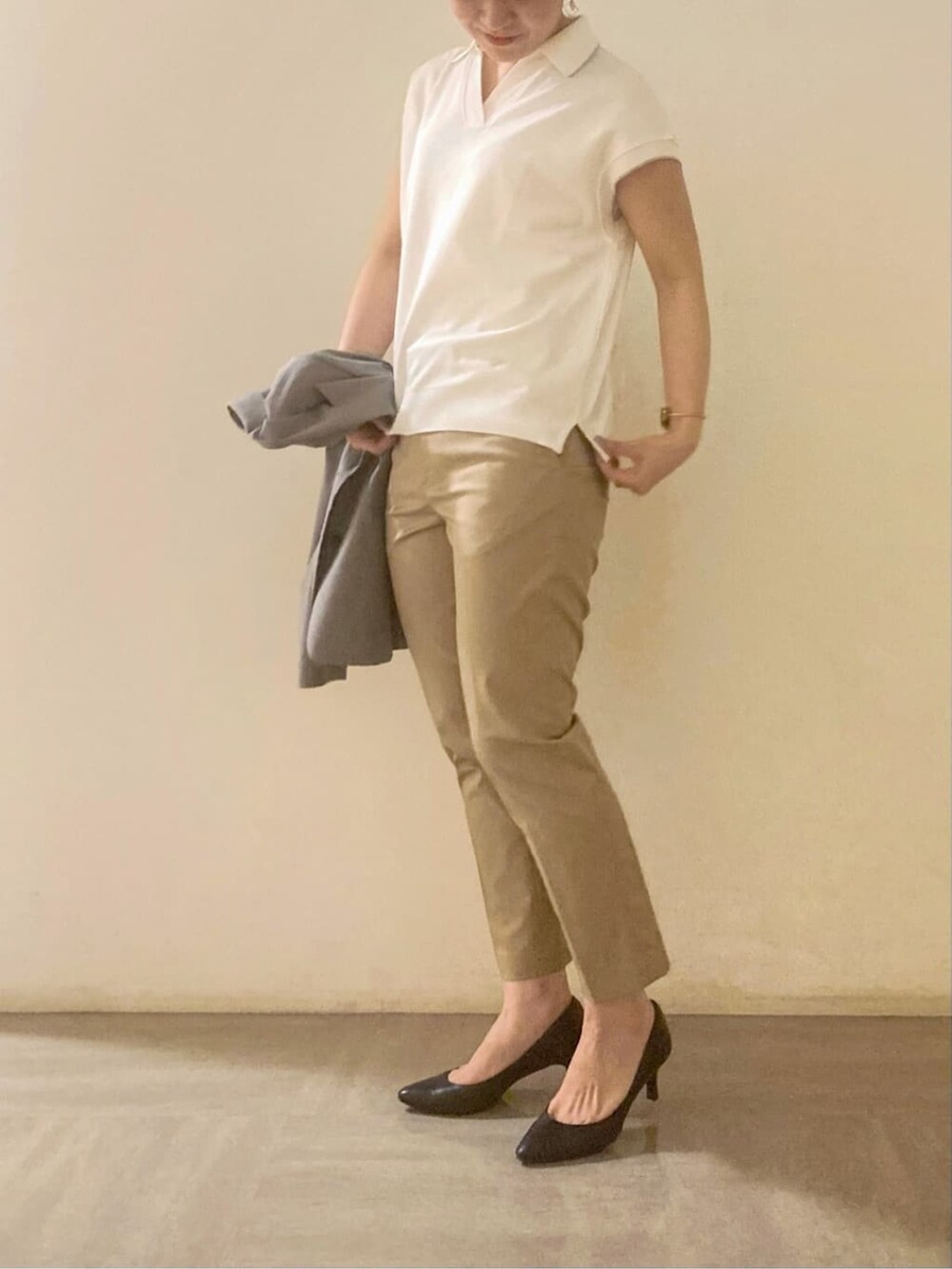 ベージュ系のチノパンツ、グレー系のテーラードジャケット、ホワイト系のポロシャツを着用したレディースの夏コーディネートの2枚目の写真
