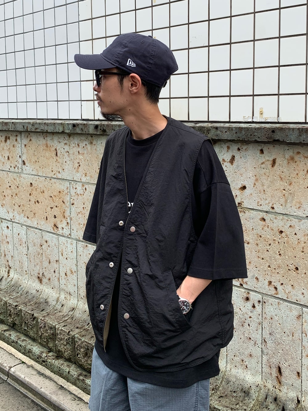 ブラック系のTシャツ/カットソー、グリーン系のベスト、ブルー系のその他パンツを着用したメンズの夏コーディネートの2枚目の写真