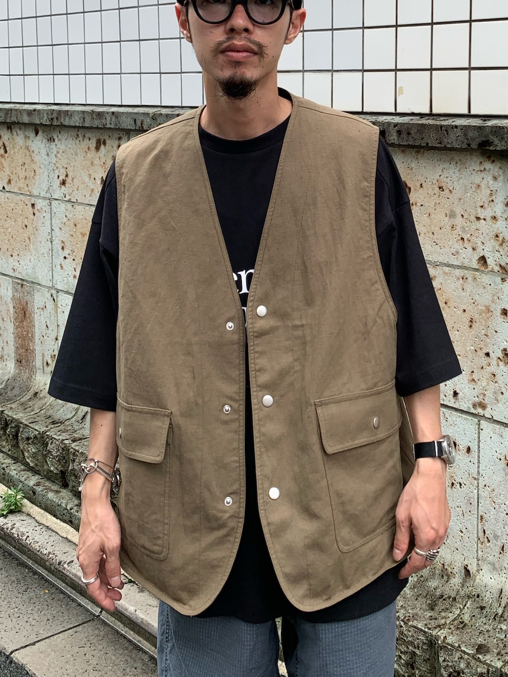 ブラック系のTシャツ/カットソー、グリーン系のベスト、ブルー系のその他パンツを着用したメンズの夏コーディネートの3枚目の写真