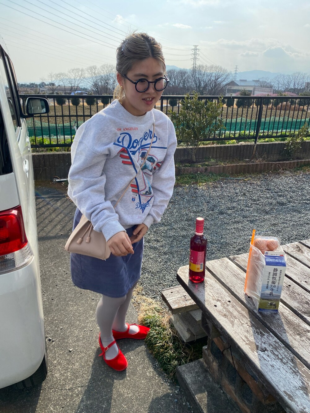 パープル系のスカート、レッド系のパンプス、グレー系のスウェットを着用したレディースの春コーディネートの2枚目の写真