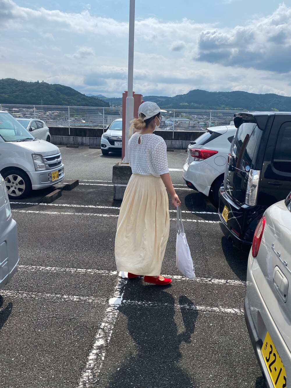 ホワイト系のTシャツ/カットソー、レッド系のパンプス、ホワイト系のトートバッグを着用したレディースの夏コーディネートの3枚目の写真