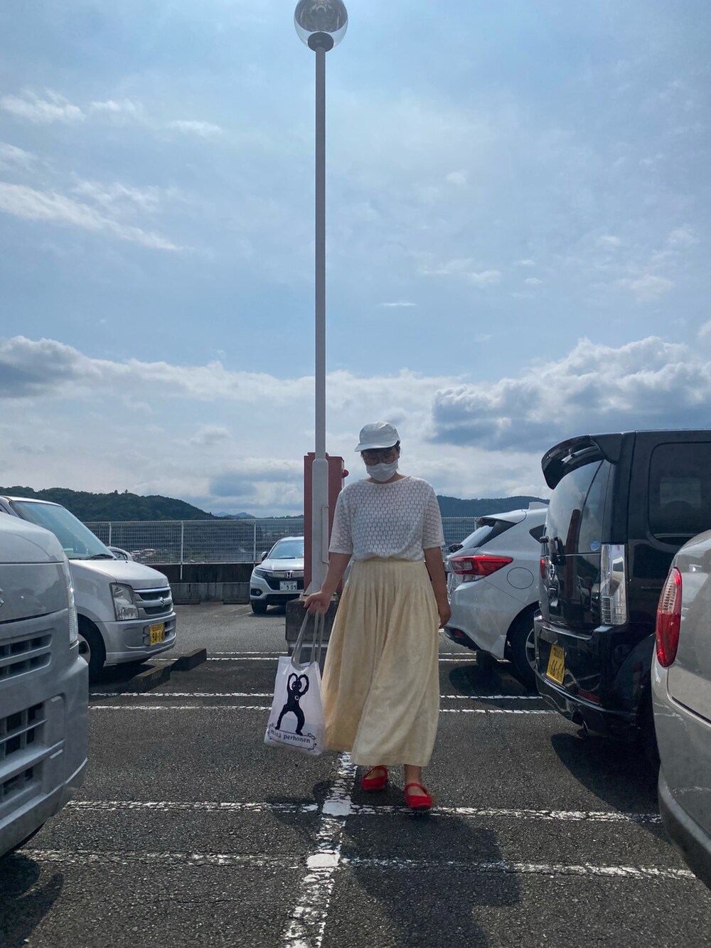 ホワイト系のTシャツ/カットソー、レッド系のパンプス、ホワイト系のトートバッグを着用したレディースの夏コーディネートの4枚目の写真