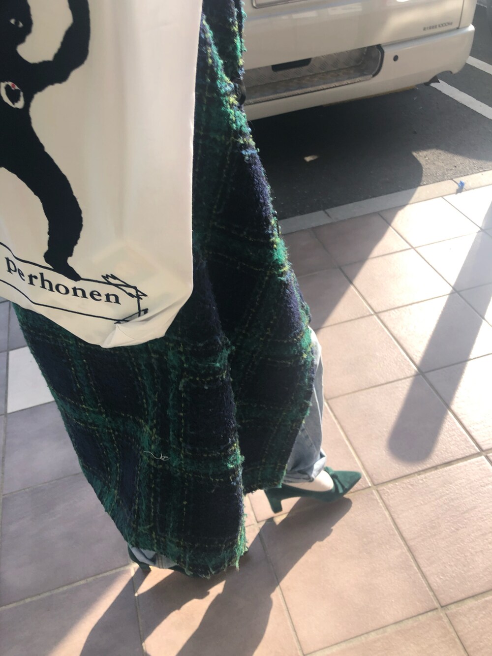 ホワイト系のトートバッグ、グリーン系のジャケット/アウター、グリーン系のパンプスを着用したレディースの冬コーディネートの3枚目の写真