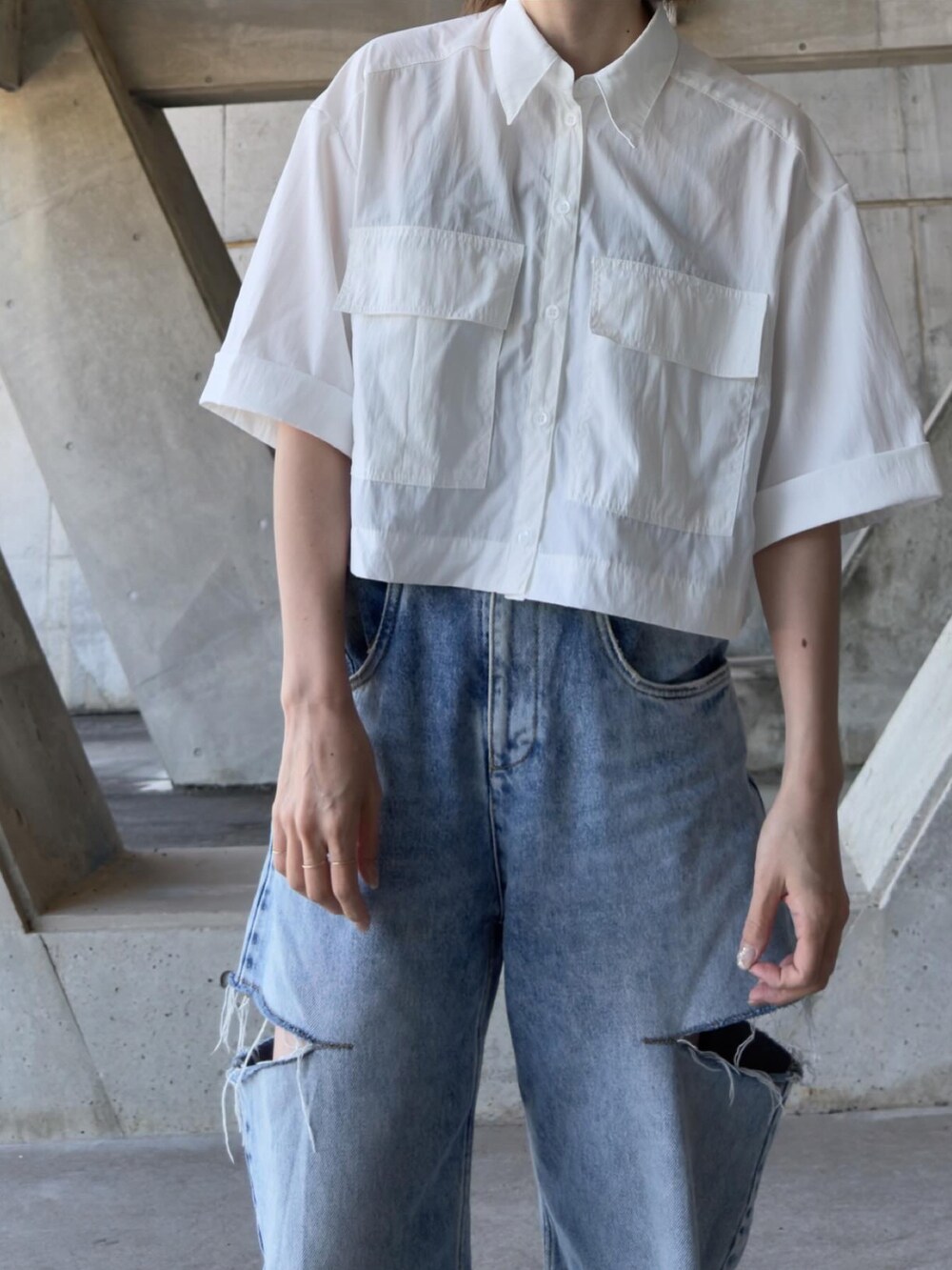 ブルー系のデニムパンツ、ブラック系のスリッポン、ホワイト系のシャツ/ブラウスを着用したレディースの春コーディネートの2枚目の写真