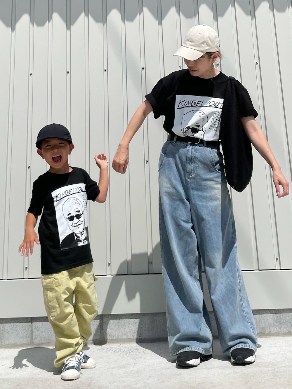 ブラック系のトートバッグ、ブラック系のスニーカー、ホワイト系のキャップを着用したレディースの夏コーディネートの3枚目の写真