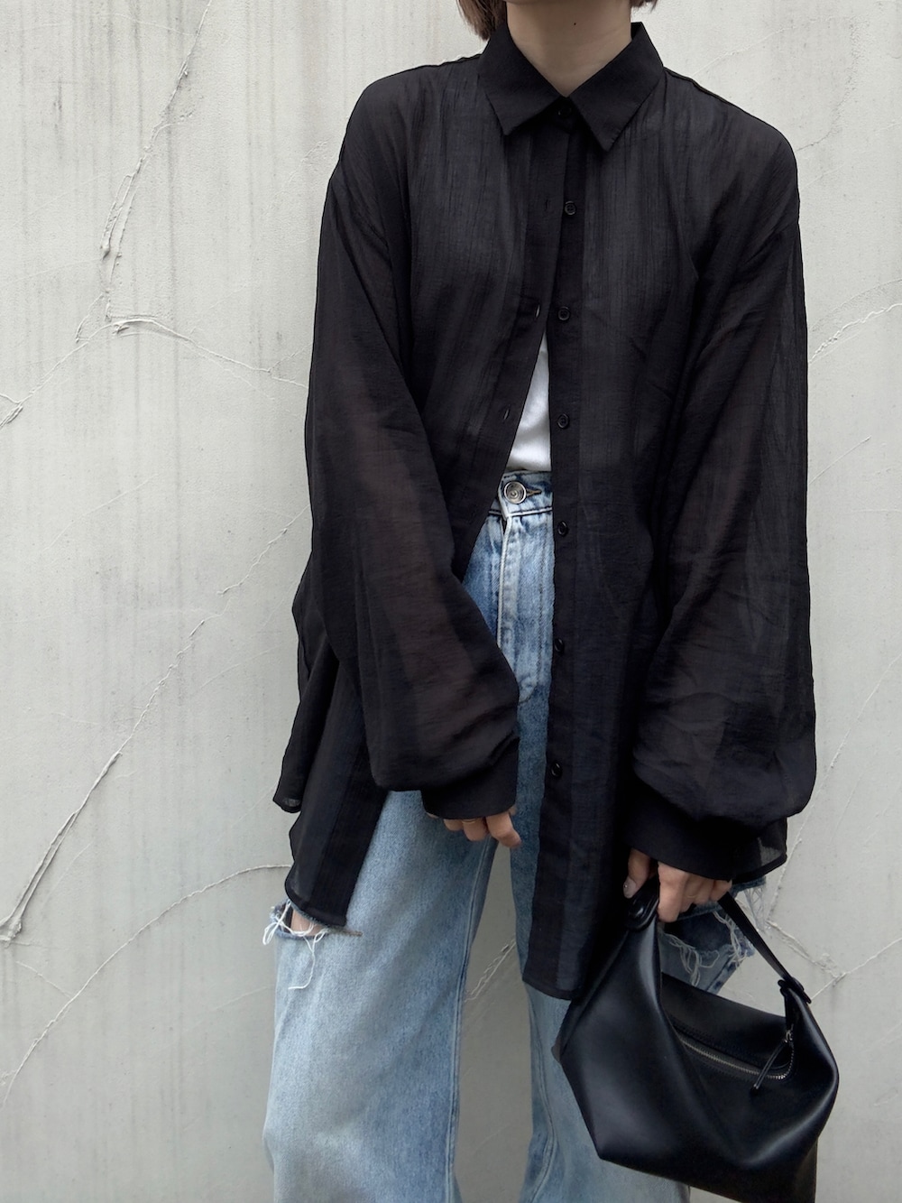 ブラック系のシャツ/ブラウス、ブルー系のデニムパンツ、ブラック系のスリッポンを着用したレディースの夏コーディネートの3枚目の写真