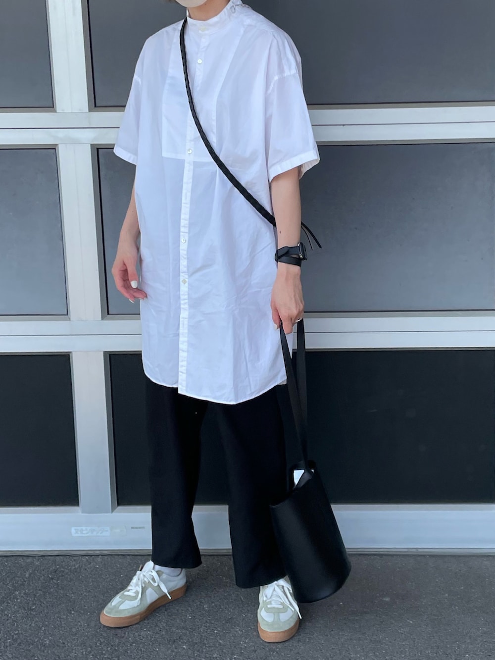 ホワイト系のシャツ/ブラウス、ブラック系のスラックス、ホワイト系のスニーカーを着用したレディースの夏コーディネートの2枚目の写真