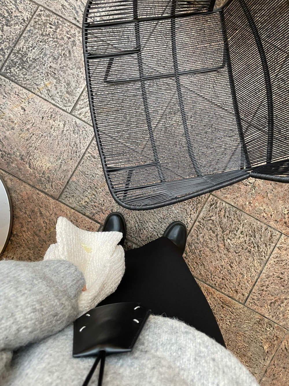 グレー系のニット/セーター、ブラック系のスカート、ブラック系のブーツを着用したレディースの冬コーディネートの3枚目の写真