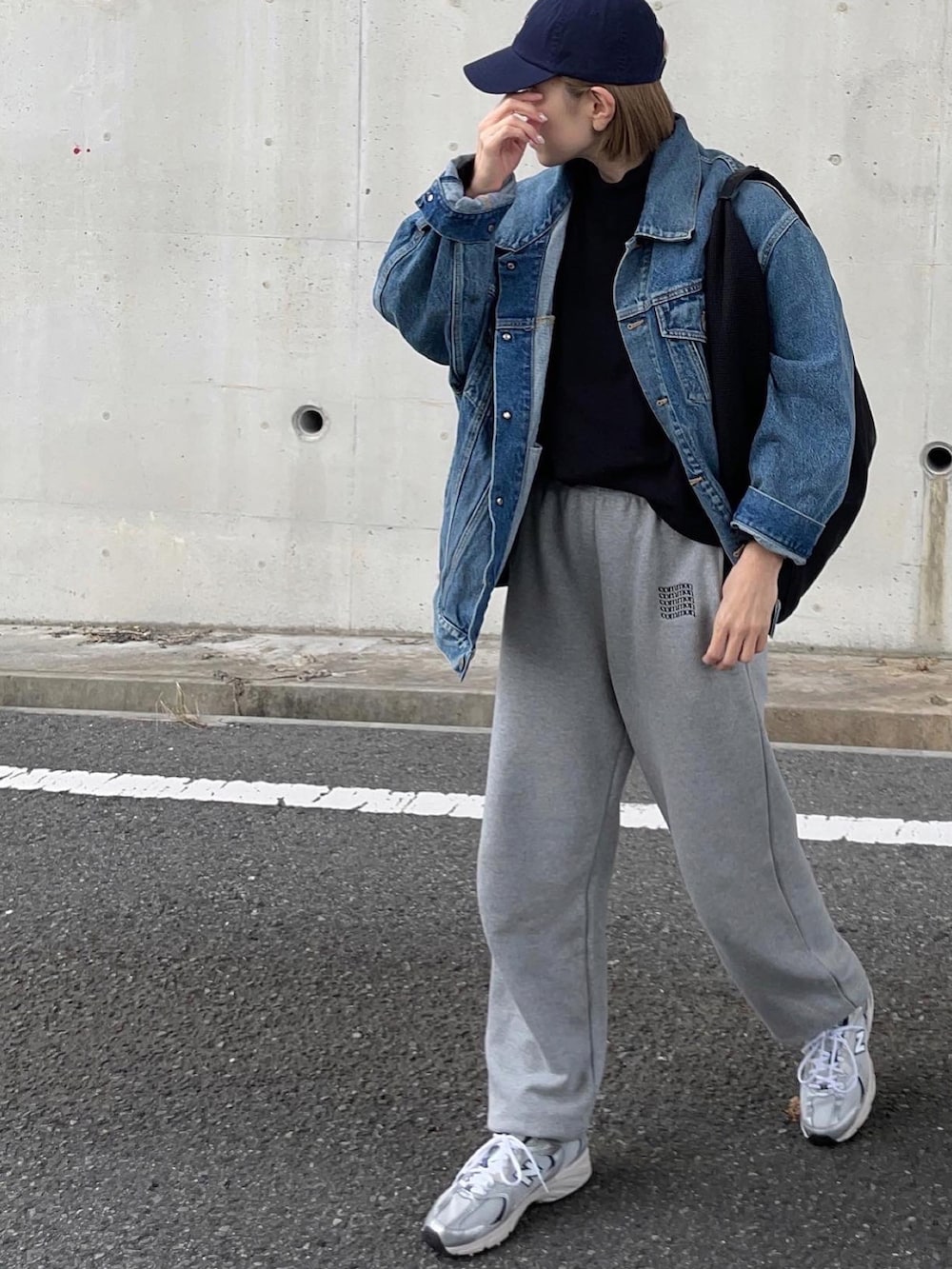 ブルー系のデニムジャケット、グレー系のスウェットパンツ、シルバー系のスニーカーを着用したレディースの冬コーディネートの3枚目の写真