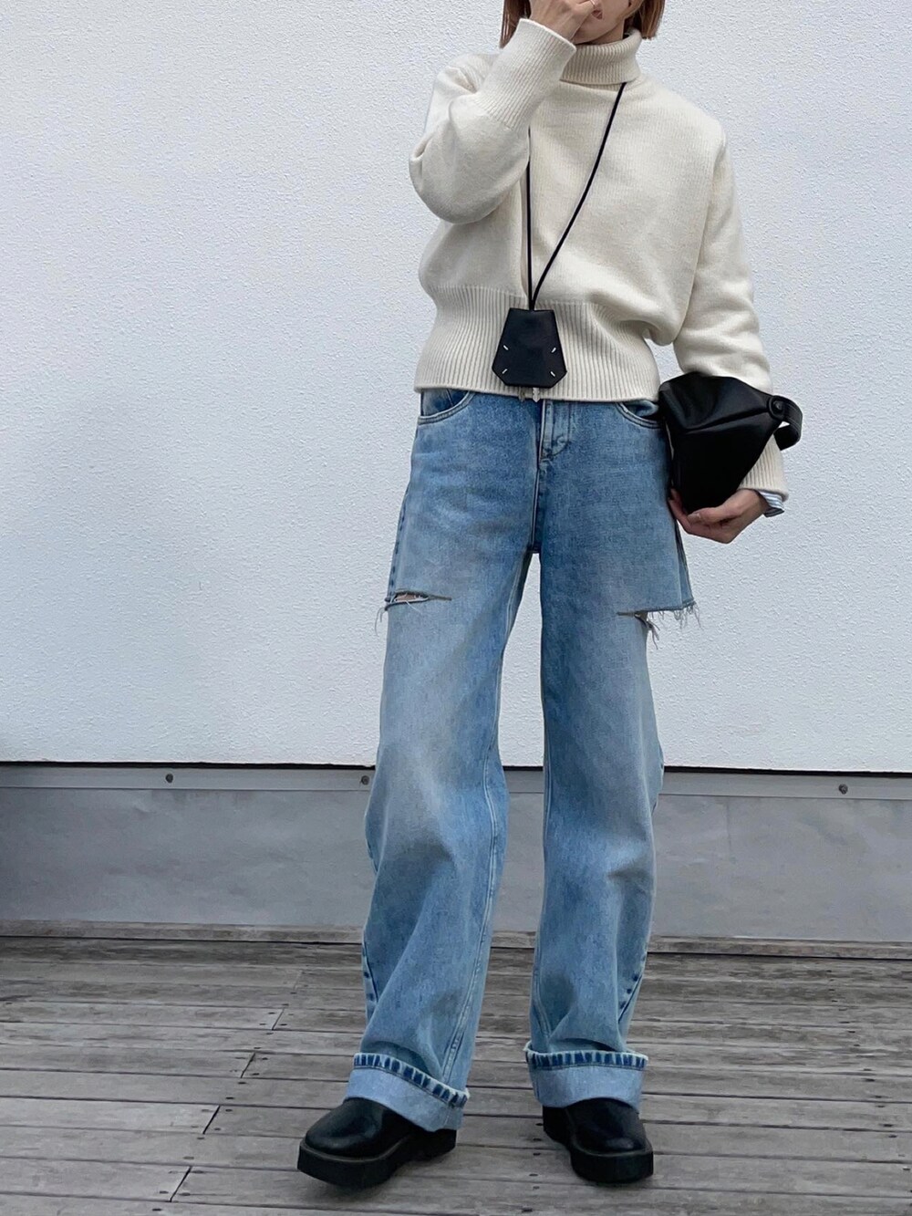 ホワイト系のニット/セーター、ブルー系のデニムパンツ、ブラック系のブーツを着用したレディースの冬コーディネートの2枚目の写真