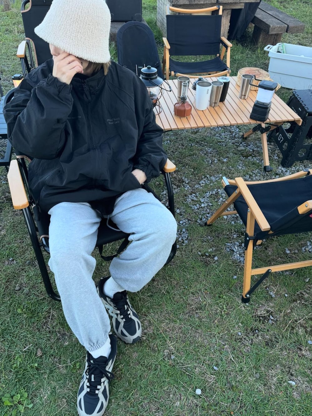 ブラック系のナイロンジャケット、グレー系のスウェットパンツ、ベージュ系のスニーカーを着用したレディースの秋コーディネートの3枚目の写真