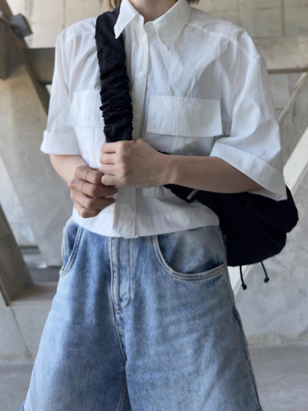 ブルー系のデニムパンツ、ブラック系のスリッポン、ホワイト系のシャツ/ブラウスを着用したレディースの春コーディネートの3枚目の写真