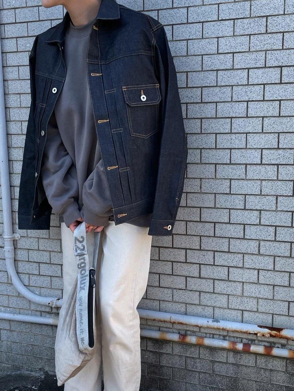 ブルー系のデニムジャケット、シルバー系のハンドバッグ、その他のスニーカーを着用したレディースの冬コーディネートの2枚目の写真