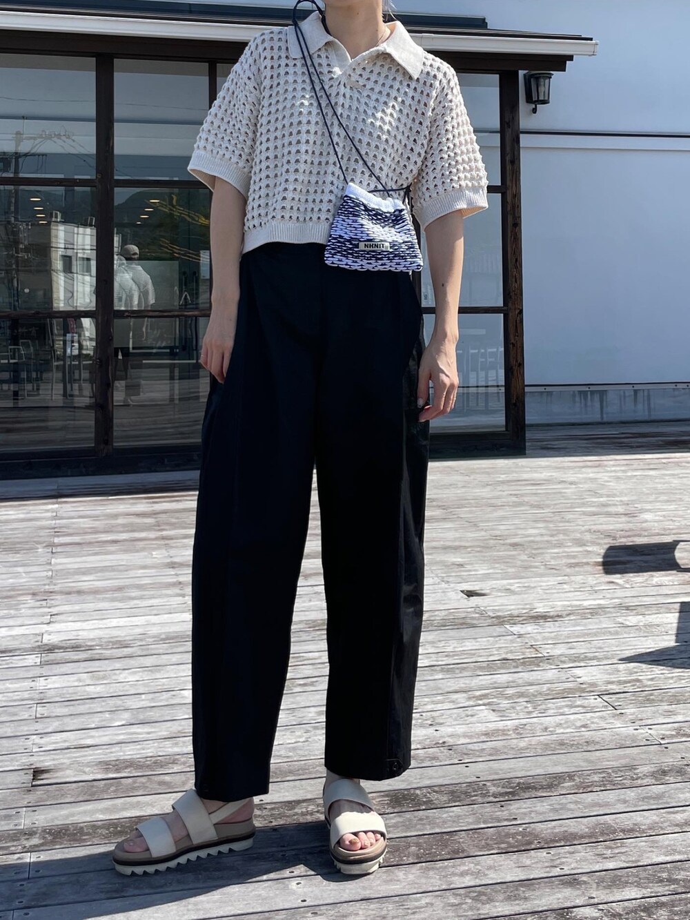 ホワイト系のトップス、ブラック系のその他パンツ、ブラック系のトートバッグを着用したレディースの夏コーディネートの2枚目の写真