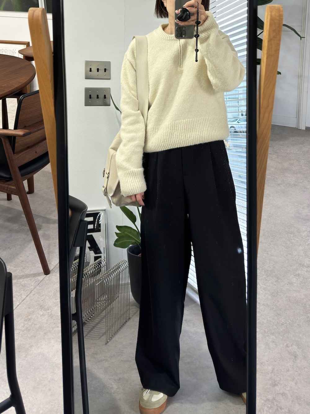 ホワイト系のニット/セーター、ブラック系のスラックス、ホワイト系のスニーカーを着用したレディースの冬コーディネートの2枚目の写真