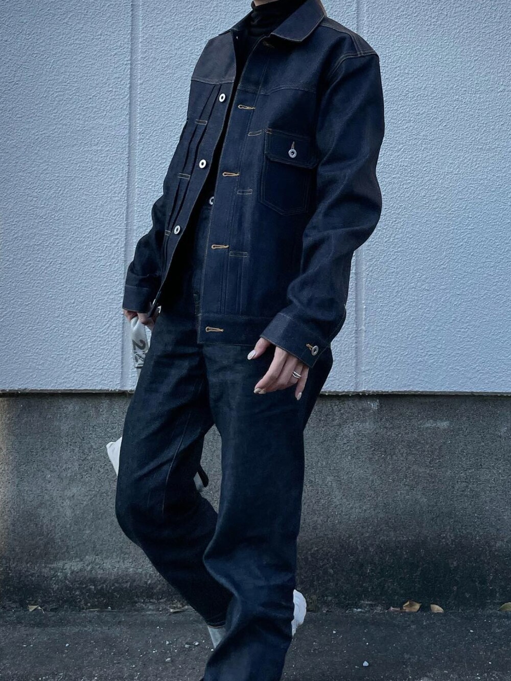 ブルー系のデニムジャケット、ブルー系のデニムパンツ、シルバー系のハンドバッグを着用したレディースの冬コーディネートの5枚目の写真