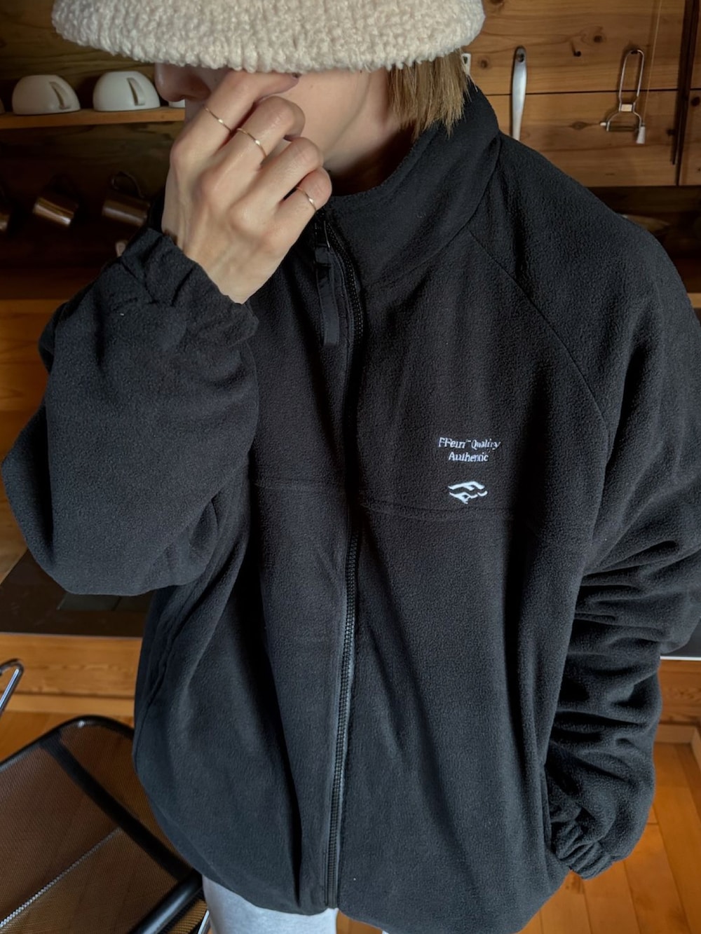 ブラック系のナイロンジャケット、グレー系のスウェットパンツ、ベージュ系のスニーカーを着用したレディースの秋コーディネートの4枚目の写真