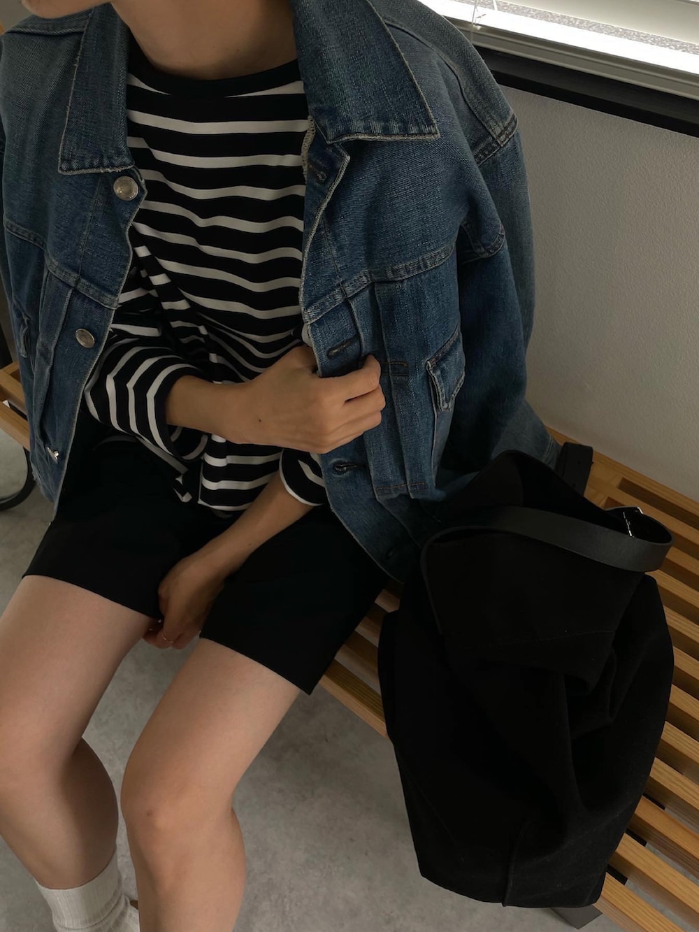 ブルー系のデニムジャケット、ブルー系のTシャツ/カットソー、ブラック系のその他パンツを着用したレディースの秋コーディネートの2枚目の写真