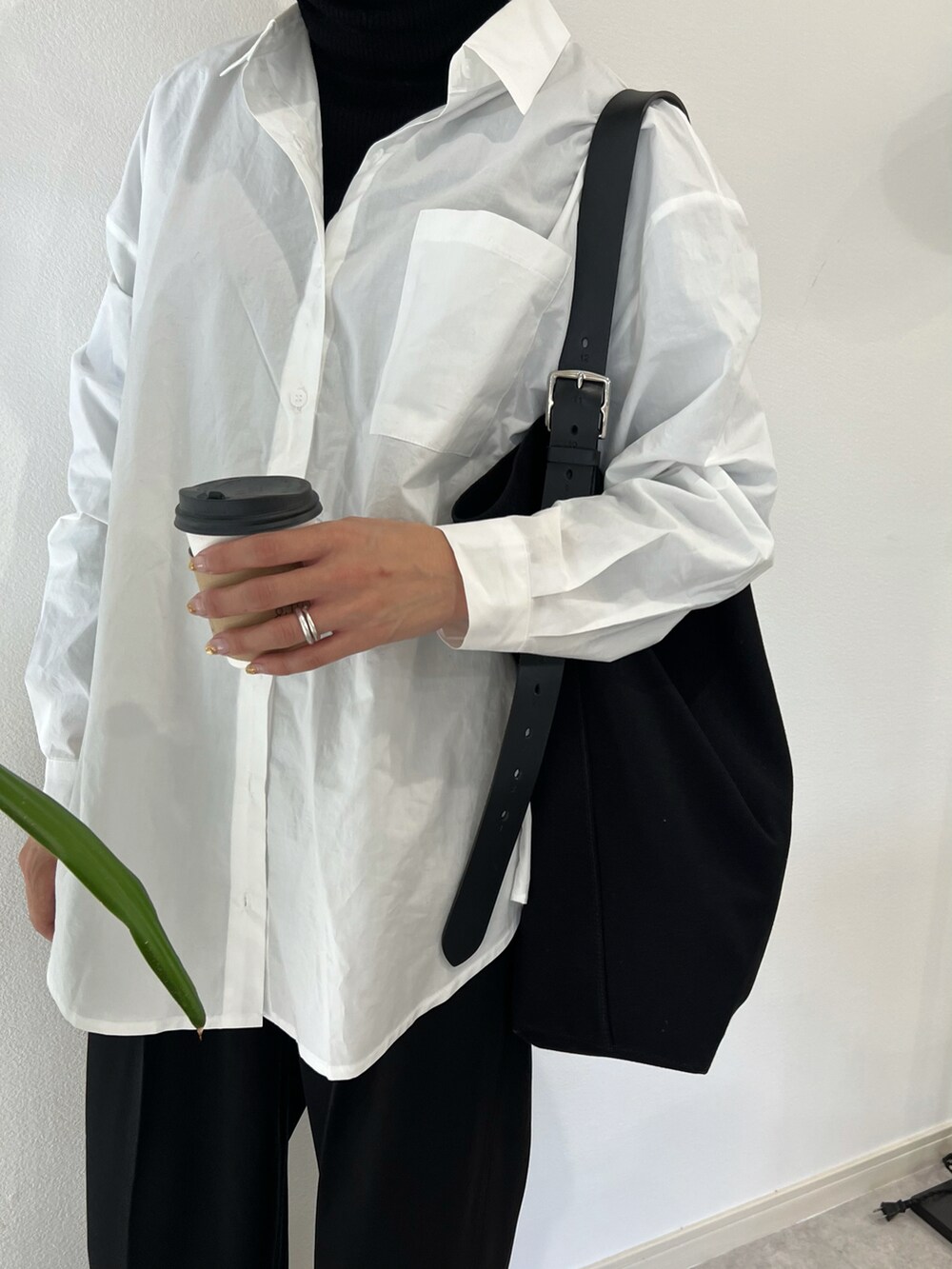 ホワイト系のシャツ/ブラウス、ブラック系のハンドバッグ、ブラック系のパンツを着用したレディースの秋コーディネートの2枚目の写真