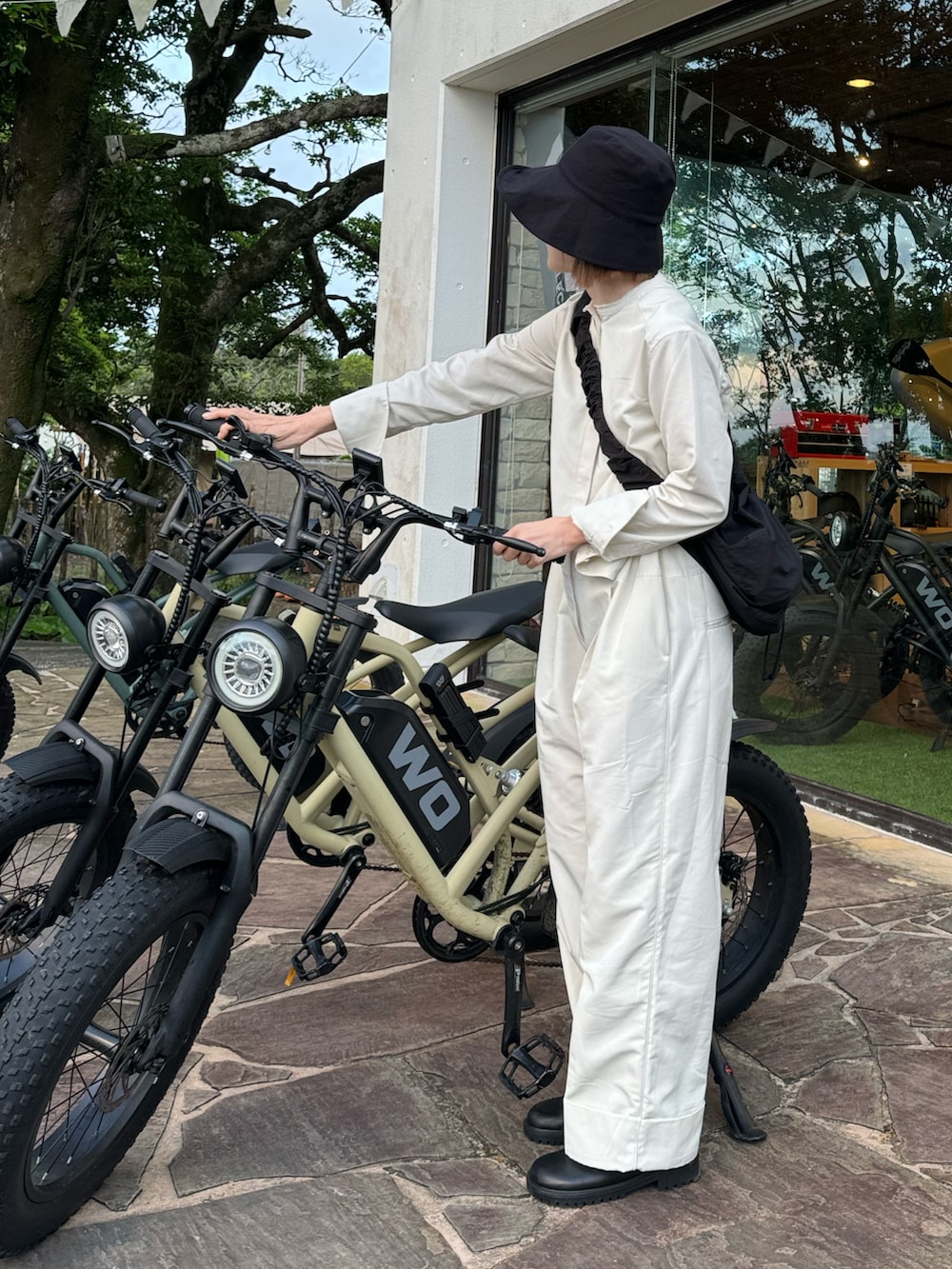 ホワイト系のつなぎ/オールインワン、ブラック系のショルダーバッグ、ブラック系のスリッポンを着用したレディースの春コーディネートの2枚目の写真