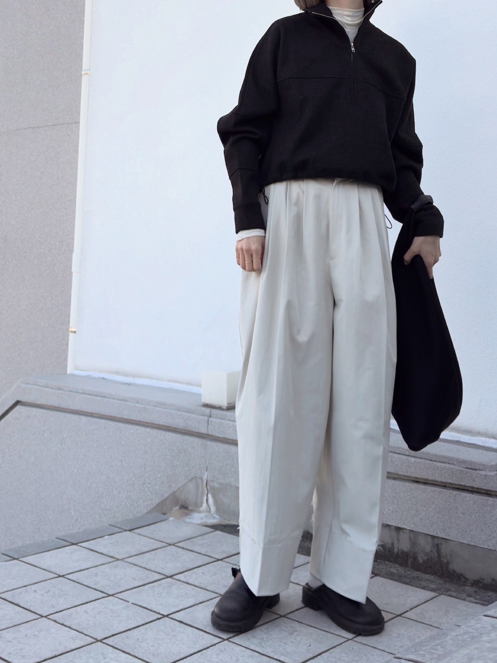 ホワイト系のTシャツ/カットソー、ブラック系のトップス、ホワイト系のパンツを着用したレディースの冬コーディネートの3枚目の写真