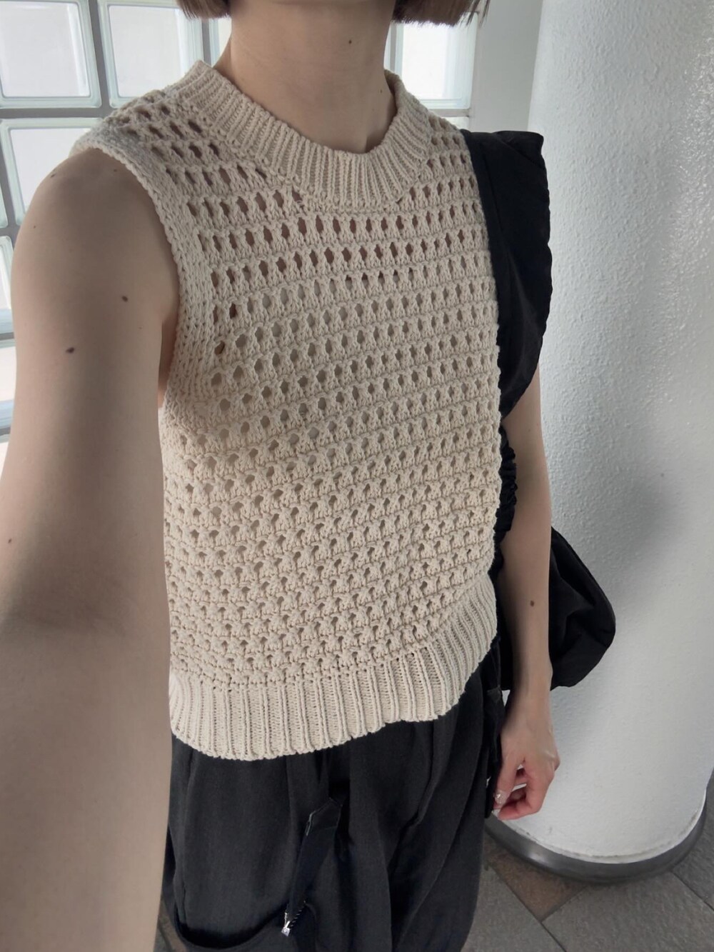 ベージュ系のベスト、グレー系のその他パンツ、ホワイト系のスニーカーを着用したレディースの春コーディネートの3枚目の写真