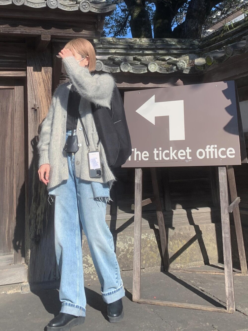 グレー系のカーディガン/ボレロ、ブルー系のデニムパンツ、ブラック系のブーツを着用したレディースの冬コーディネートの2枚目の写真