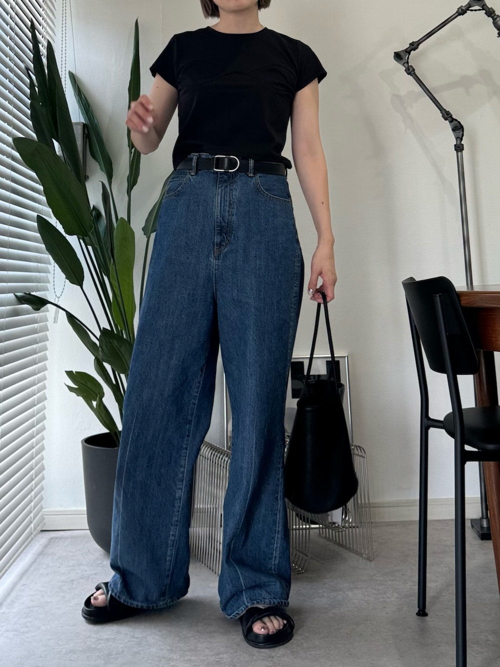 ブルー系のデニムパンツ、ホワイト系のTシャツ/カットソー、ブラック系のバッグを着用したレディースの夏コーディネートの2枚目の写真