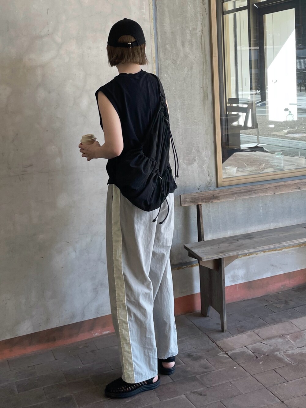 ブラック系のショルダーバッグ、ブラック系のサンダル、ブラック系のトップスを着用したレディースの夏コーディネートの2枚目の写真