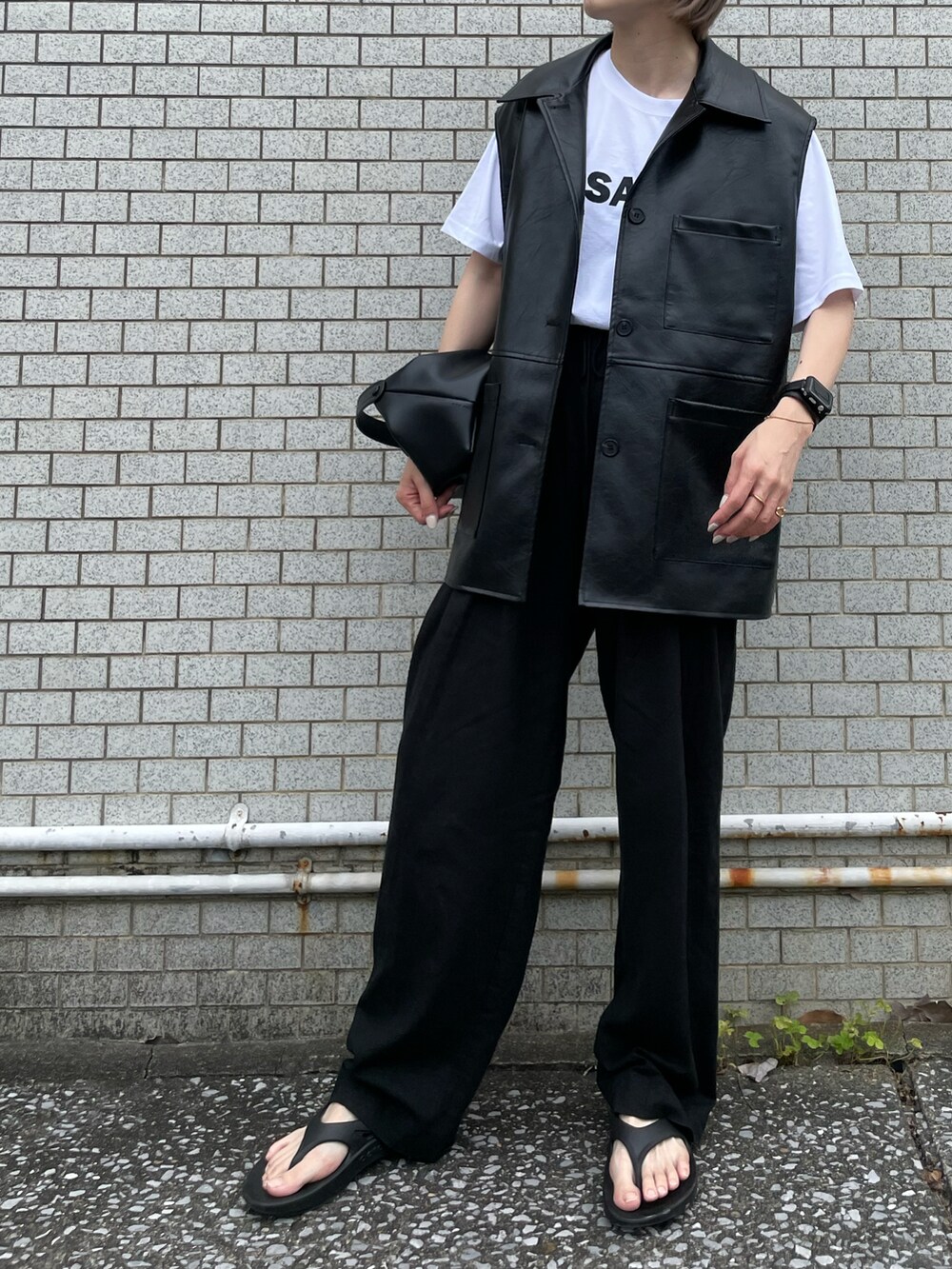 ホワイト系のTシャツ/カットソー、ブラック系のベスト、ブラック系のサンダルを着用したレディースの夏コーディネートの3枚目の写真