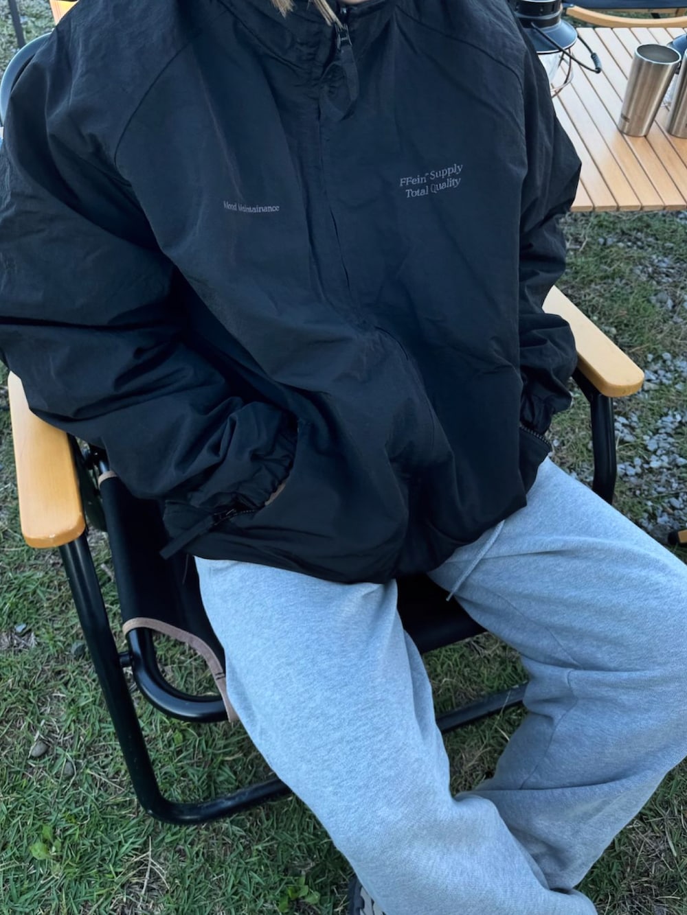 ブラック系のナイロンジャケット、グレー系のスウェットパンツ、ベージュ系のスニーカーを着用したレディースの秋コーディネートの2枚目の写真