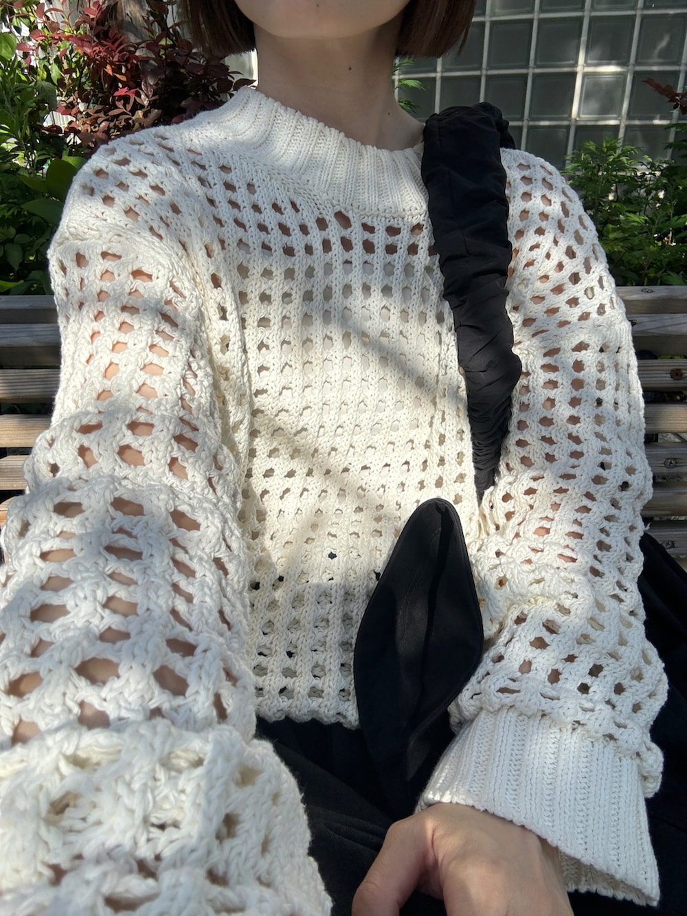 ホワイト系のニット/セーター、グレー系のその他パンツ、ホワイト系のスニーカーを着用したレディースの春コーディネートの2枚目の写真