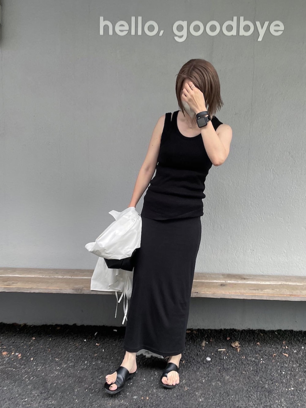 ブラック系のスカート、ブラック系のサンダル、ブラック系のバッグを着用したレディースの夏コーディネートの2枚目の写真