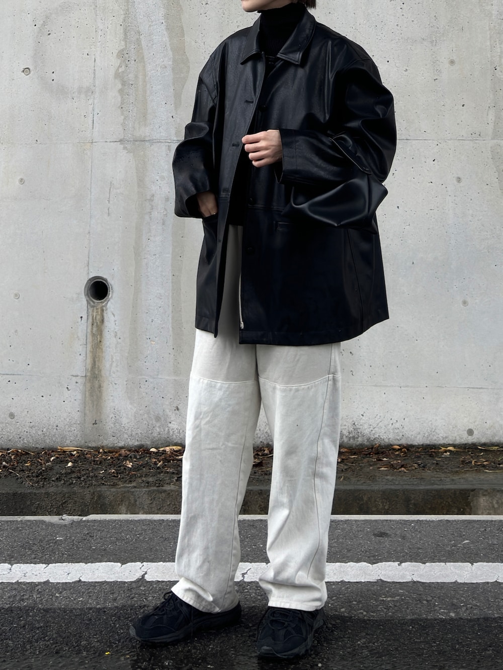 ブラック系のステンカラーコート、ブラック系のニット/セーター、ベージュ系のその他パンツを着用したレディースの冬コーディネートの2枚目の写真