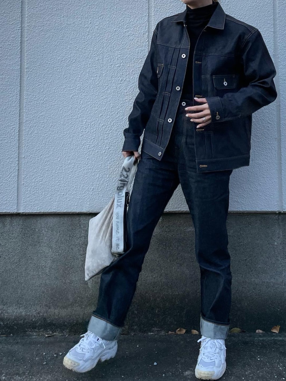 ブルー系のデニムジャケット、ブルー系のデニムパンツ、シルバー系のハンドバッグを着用したレディースの冬コーディネートの3枚目の写真