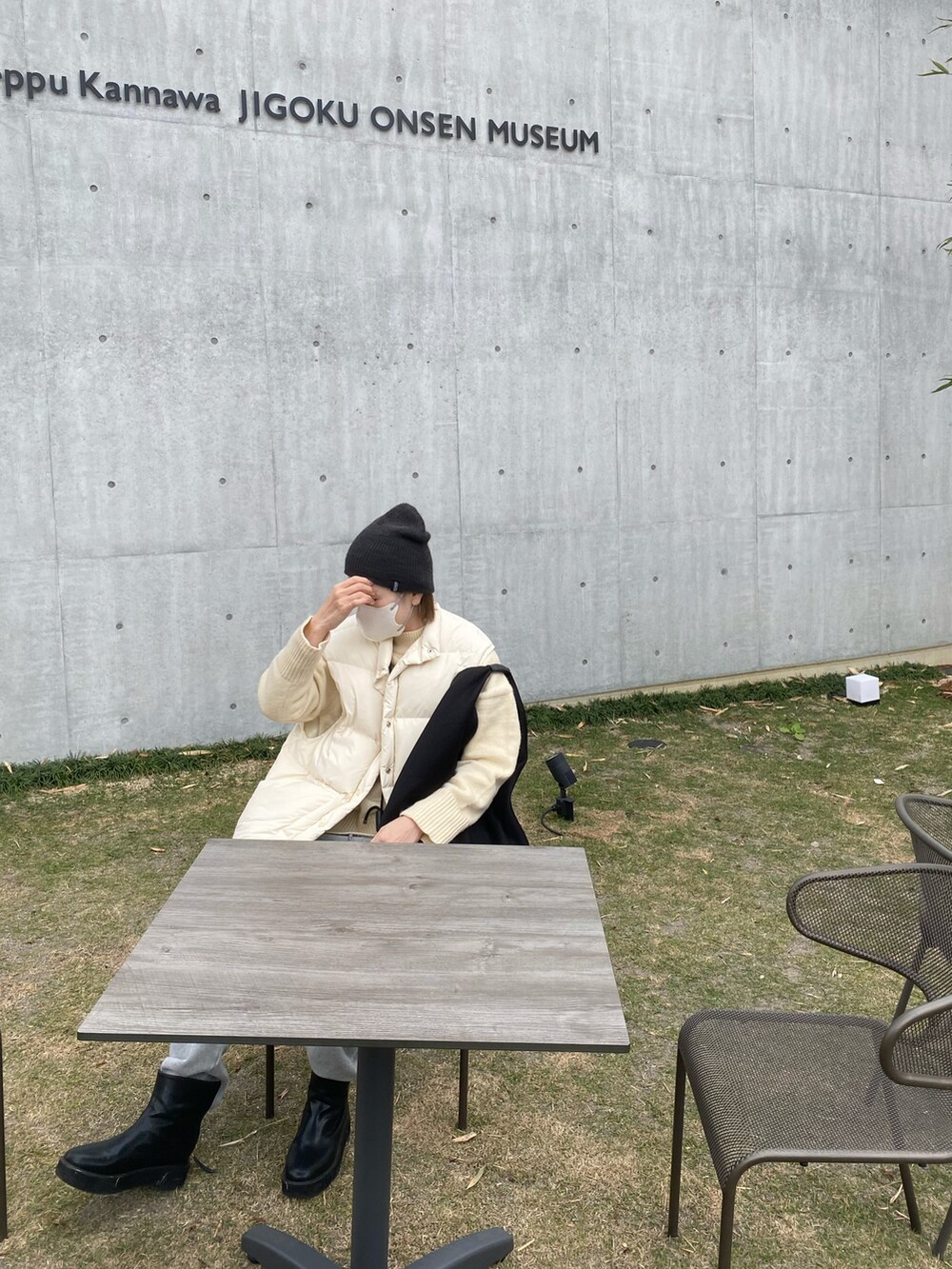 ホワイト系のダウンベスト、ブラック系のトートバッグ、グレー系のスウェットパンツを着用したレディースの冬コーディネートの2枚目の写真