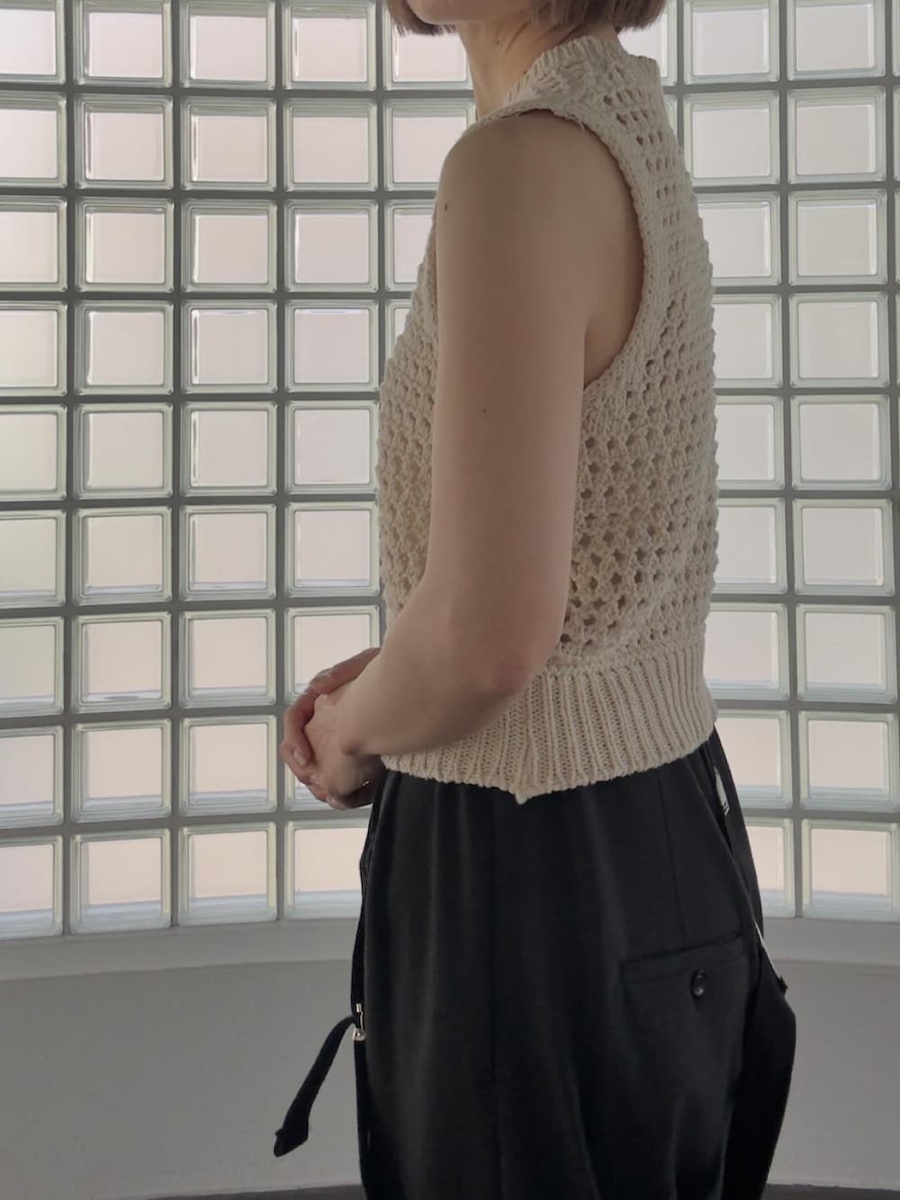 ベージュ系のベスト、グレー系のその他パンツ、ホワイト系のスニーカーを着用したレディースの春コーディネートの2枚目の写真