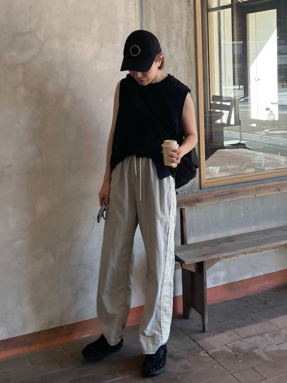 ブラック系のショルダーバッグ、ブラック系のサンダル、ブラック系のトップスを着用したレディースの夏コーディネートの3枚目の写真