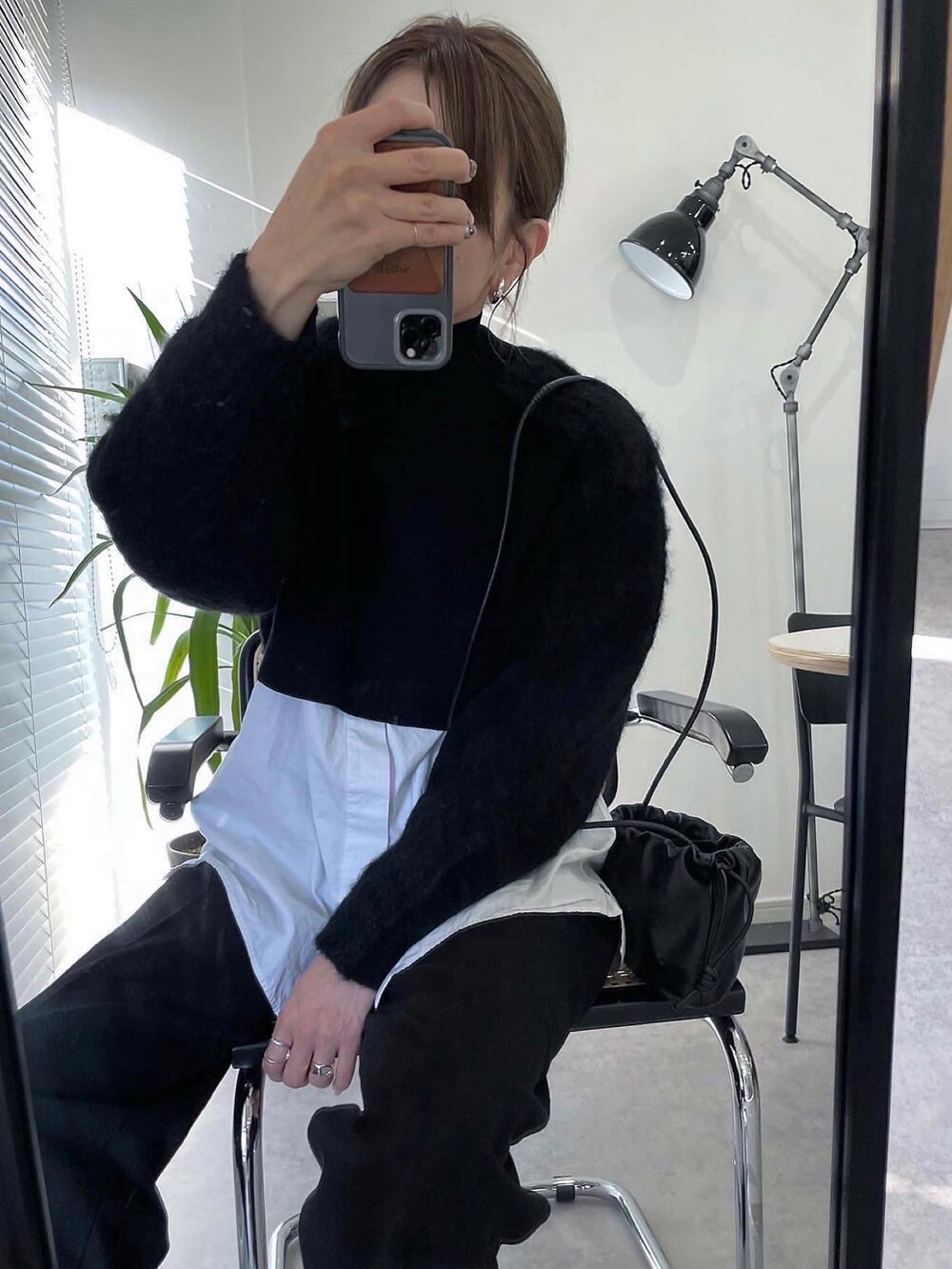 ブラック系のニット/セーター、ブラック系のハンドバッグ、ブラック系のパンツを着用したレディースの冬コーディネートの4枚目の写真