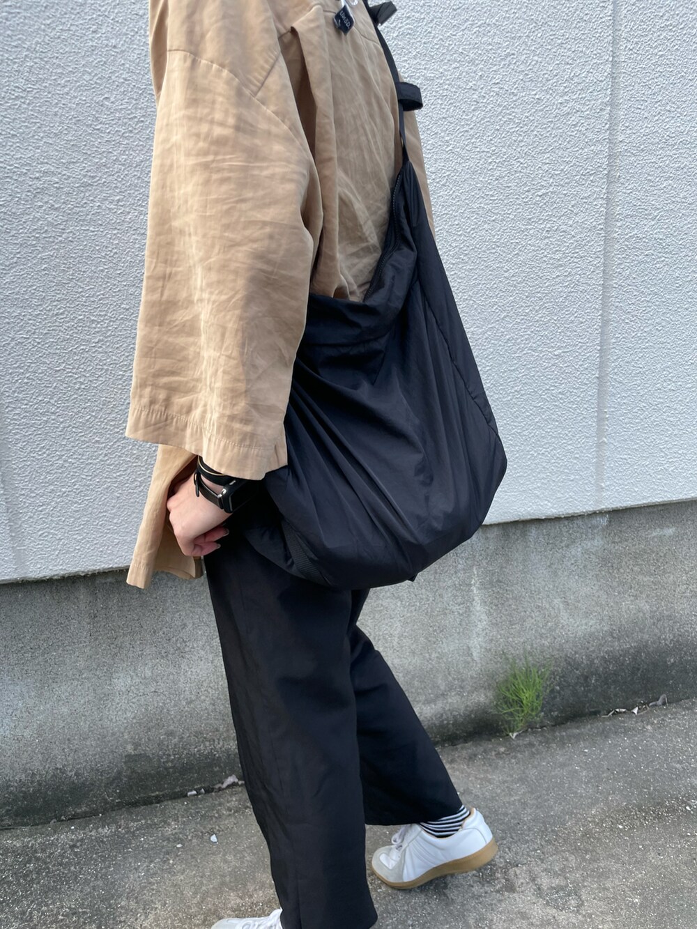 ブラウン系のシャツ/ブラウス、ブラック系のスラックス、ホワイト系のスニーカーを着用したレディースの夏コーディネートの4枚目の写真