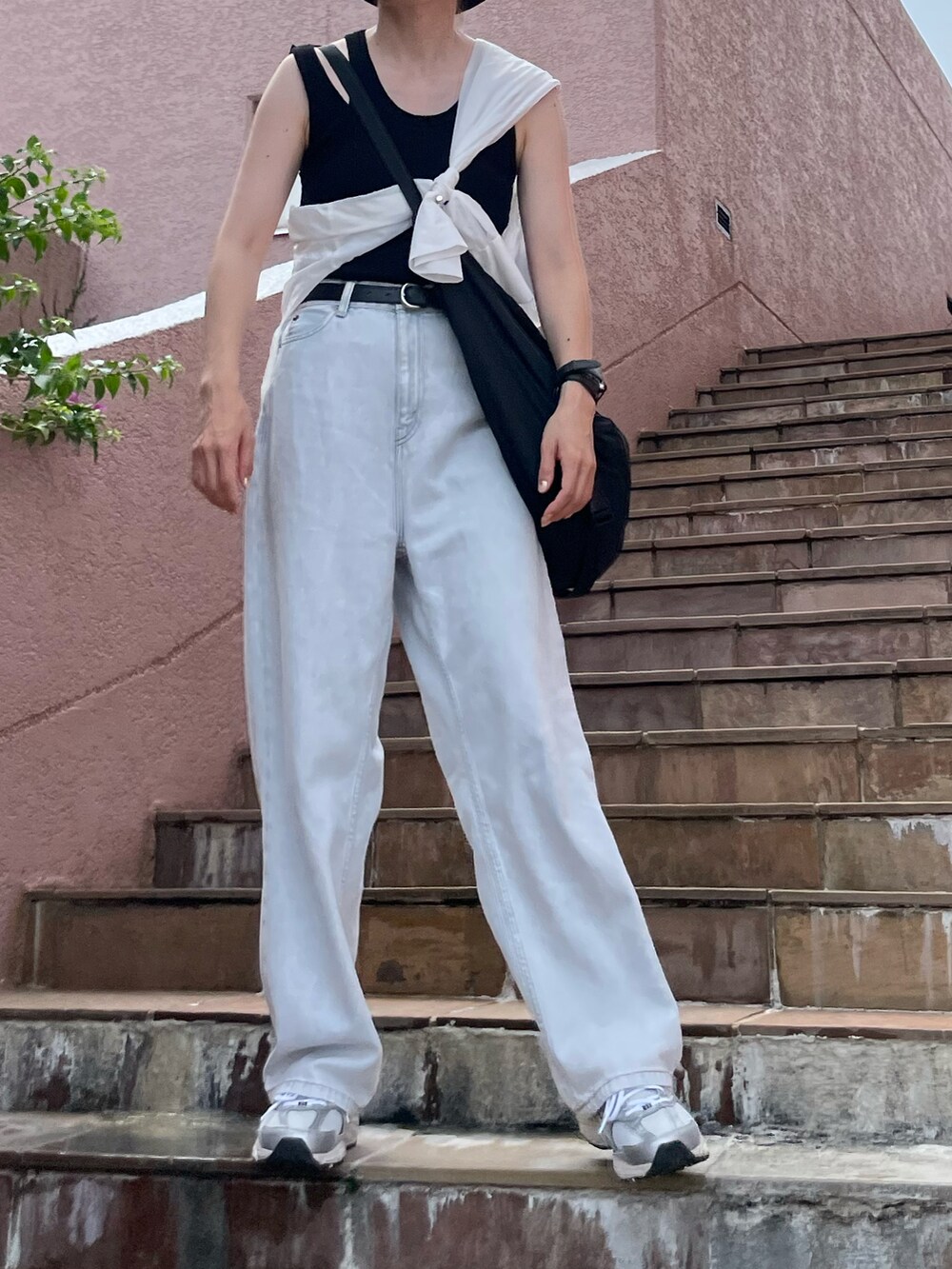 ブラック系のTシャツ/カットソー、ブルー系のデニムパンツ、シルバー系のスニーカーを着用したレディースの夏コーディネートの2枚目の写真