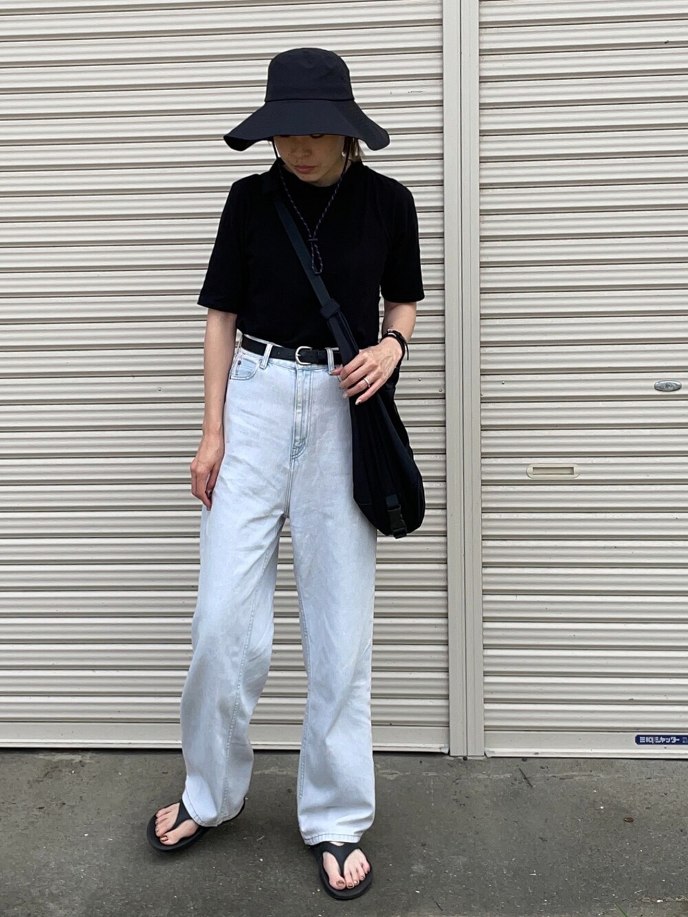 ブラック系のTシャツ/カットソー、ブルー系のデニムパンツ、ブラック系のサンダルを着用したレディースの夏コーディネートの2枚目の写真