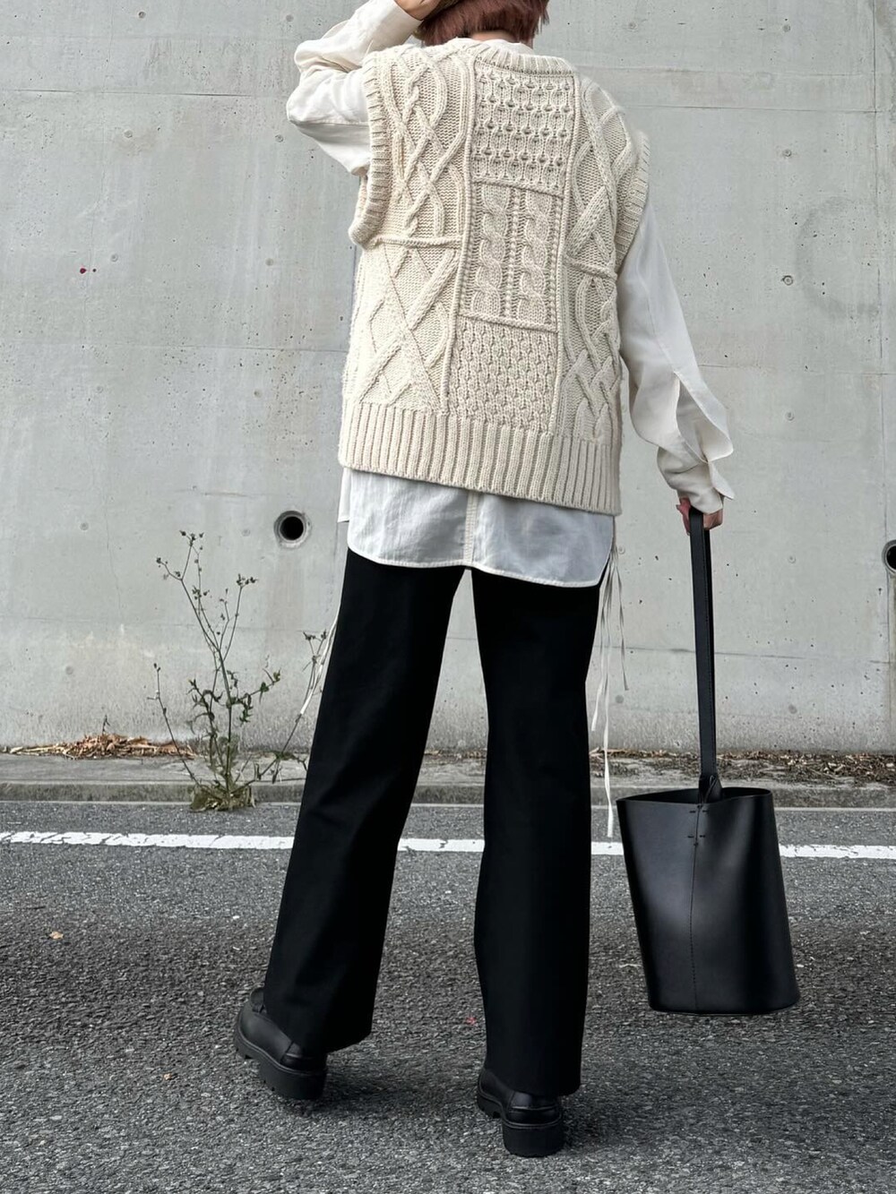 ホワイト系のシャツ/ブラウス、ベージュ系のニット/セーター、ブラック系のローファーを着用したレディースの春コーディネートの2枚目の写真