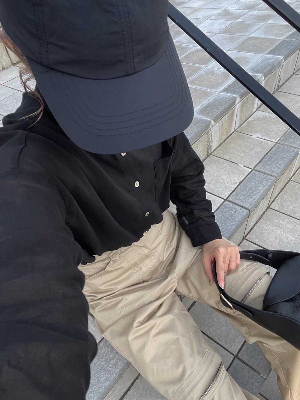 ブラック系のシャツ/ブラウス、ベージュ系のチノパンツ、ブラック系のスニーカーを着用したレディースの夏コーディネートの2枚目の写真