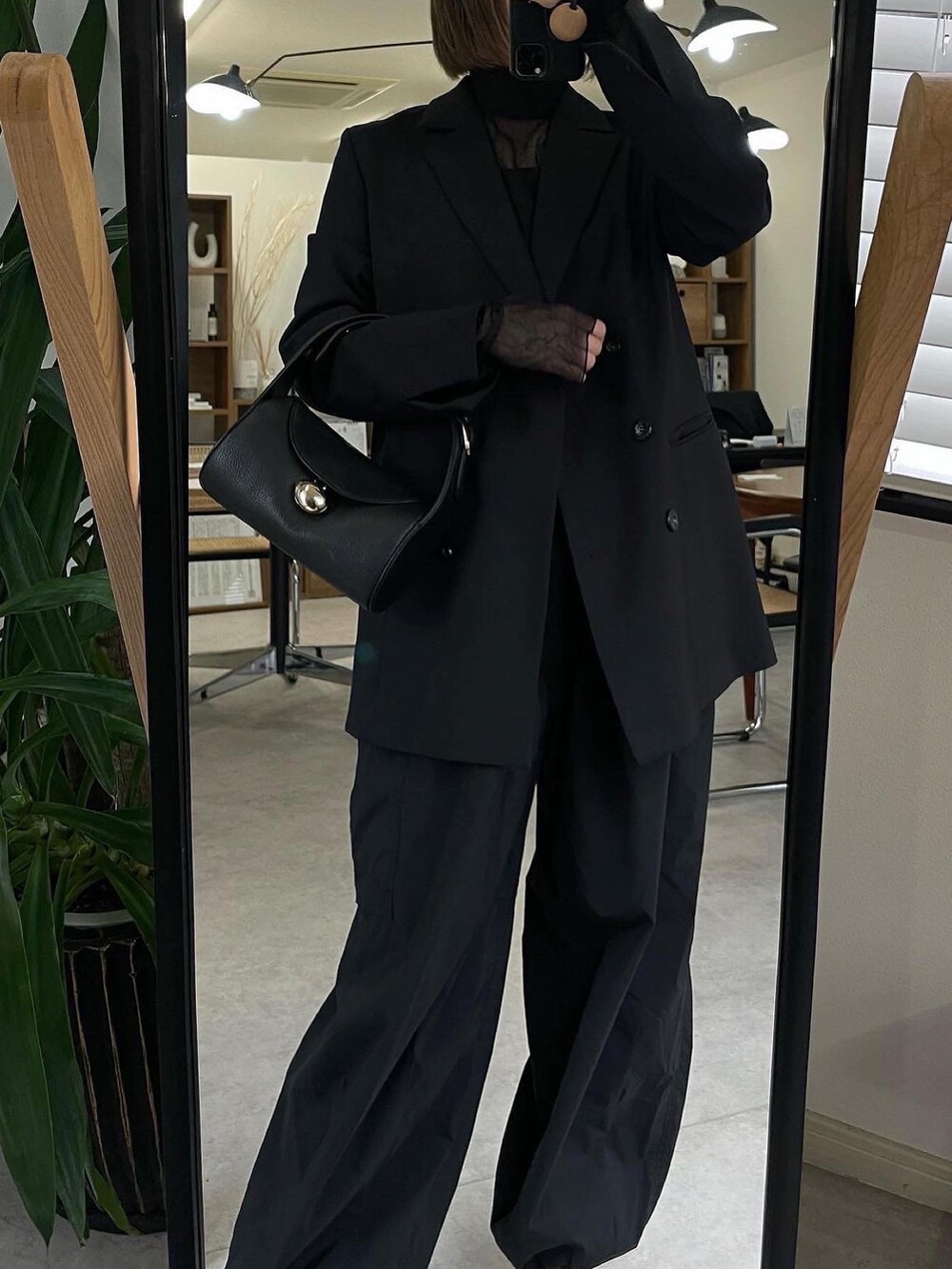 ブラック系のシャツ/ブラウス、ブラック系のカーゴパンツ、ブラック系のサンダルを着用したレディースの春コーディネートの2枚目の写真