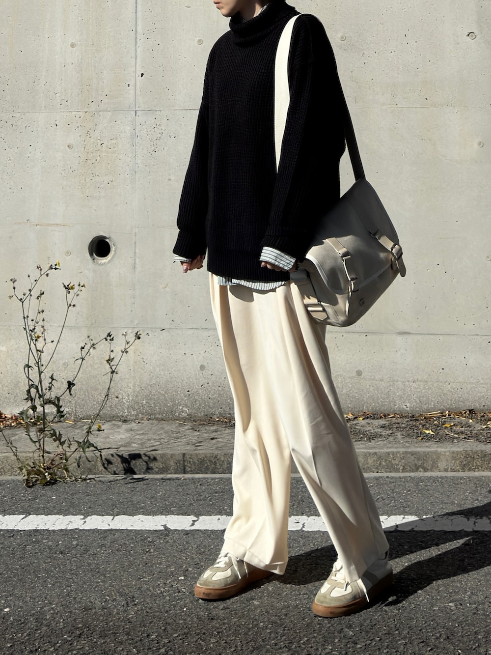 ブラック系のニット/セーター、グリーン系のシャツ/ブラウス、ホワイト系のチノパンツを着用したレディースの冬コーディネートの2枚目の写真