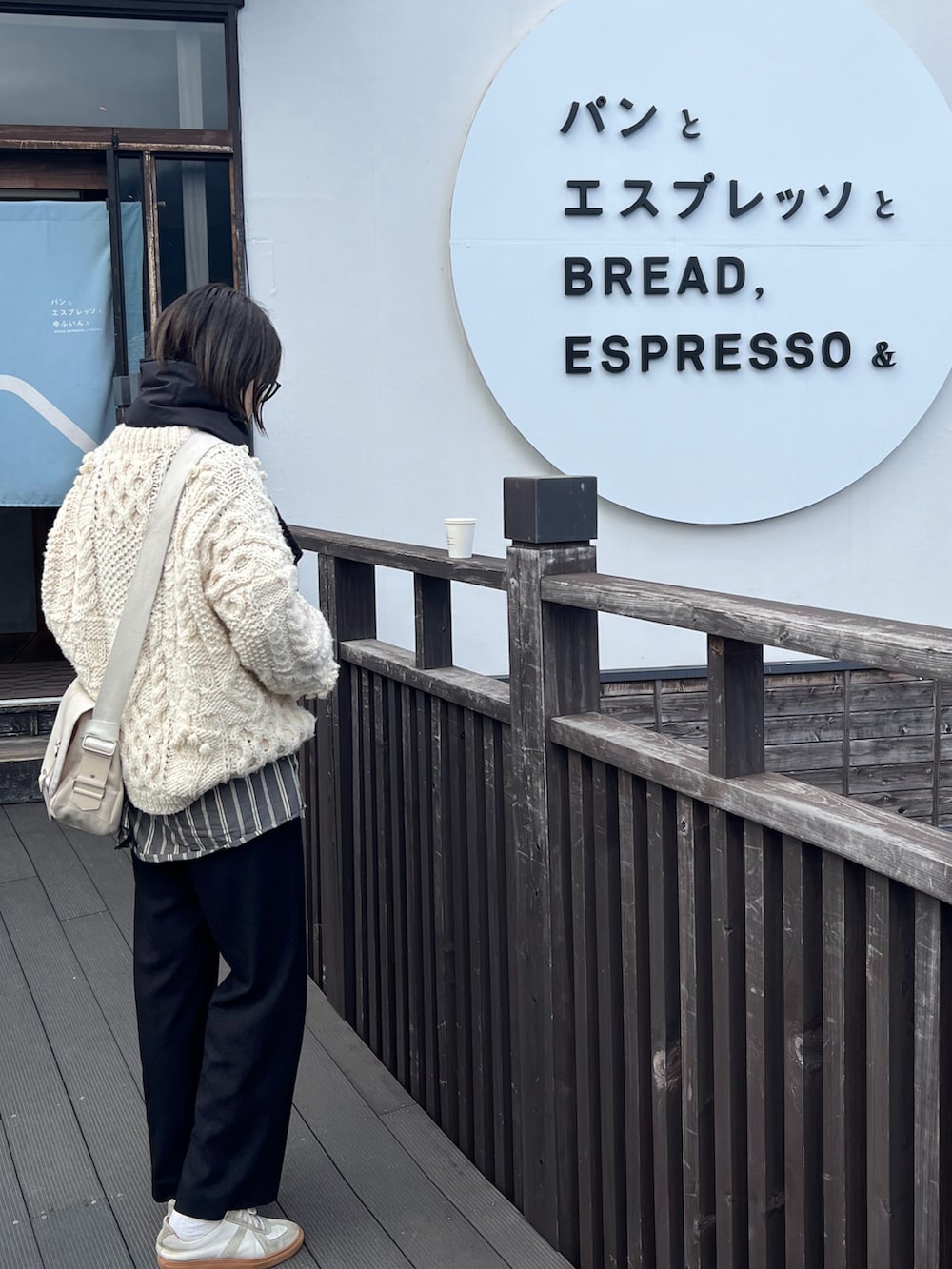 ホワイト系のニット/セーター、グレー系のシャツ/ブラウス、ホワイト系のスニーカーを着用したレディースの冬コーディネートの3枚目の写真